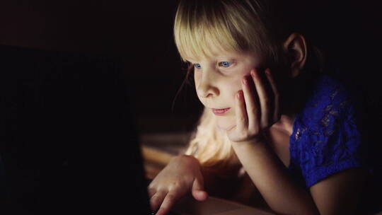女孩看卡通上的笔记本电脑视频素材模板下载