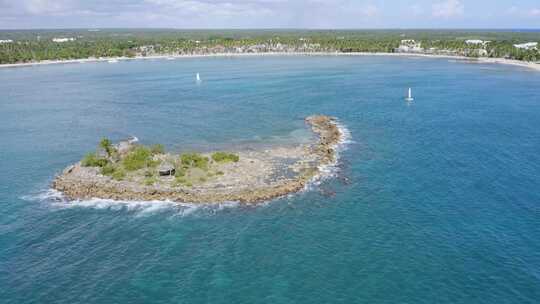 在加勒比海绿松石色的海上环绕着岩石小岛航行的帆船；空中航行的