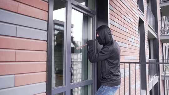 窃贼抢劫犯打破门锁进入大楼公寓房屋抢劫家