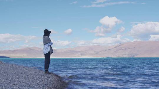 女人站在西藏佩枯措湖岸边