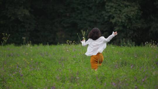 美女奔跑在森林草地上的背影自由欢乐