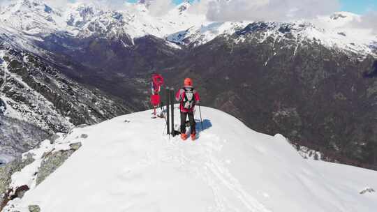 空中：山顶徒步旅行者，滑雪旅游登山雪山，阿尔卑斯山全景视频素材模板下载