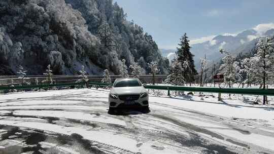 奔驰小轿车在雪地公路上旅行航拍雪景雾凇