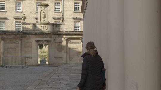 一个穿黑衣服的女人在旧石柱之间行走的宽镜头