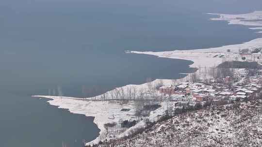 航拍冬天大雪岸边房子的岛屿湖水海水宣传片