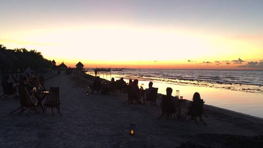 游客在海滩酒吧观看日落