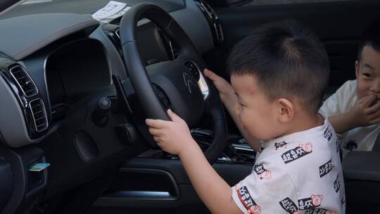 孩子坐在汽车驾驶座上假装开车游戏视频素材模板下载
