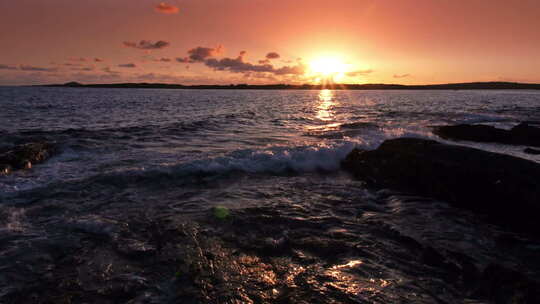 日落时海浪拍打着岩石
