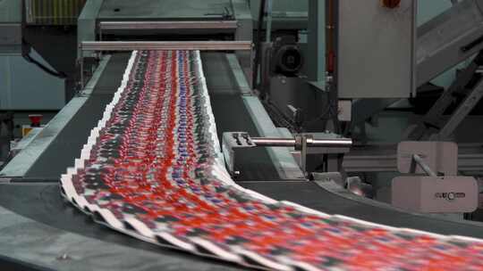 工厂出版社：在传送带上高速印刷红色报纸”视频素材模板下载