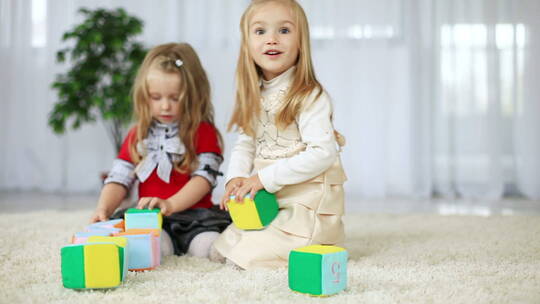女孩坐在地毯上玩玩具视频素材模板下载