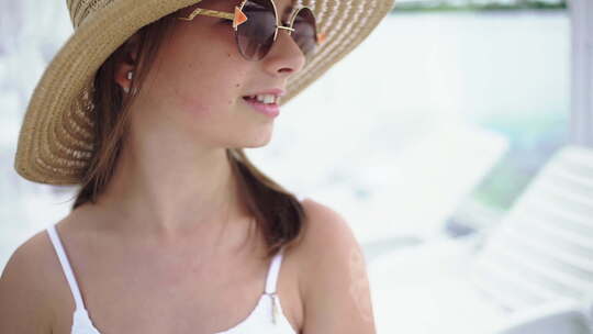 海滩上戴着帽子和太阳镜的美丽年轻女孩视频素材模板下载
