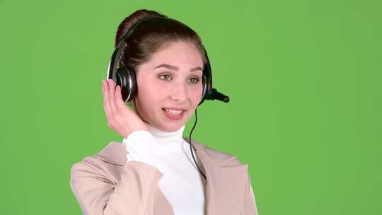 支持人员通过耳机与客户交谈。绿屏。慢动作