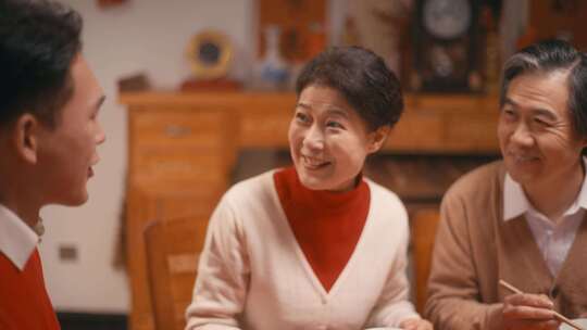 一家人吃团圆饭妈妈给儿子夹菜