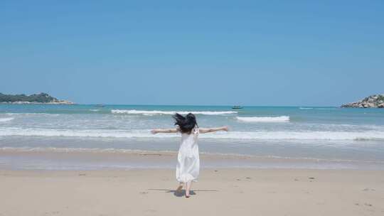 穿着白裙的女孩奔向大海