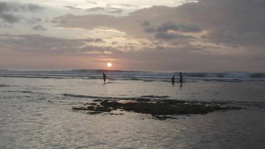 日落时人们在海滩上散步