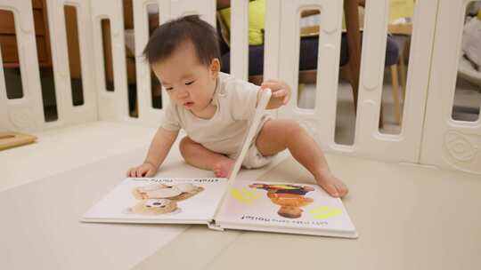 小孩宝宝坐在地垫上看触摸书绘本有肖像权