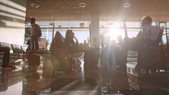 阳光透过大玻璃窗照进机场候机楼的乘客