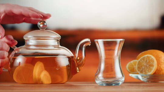 将柑橘红茶倒入玻璃杯特写