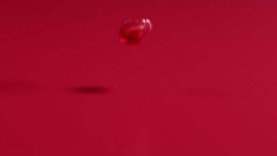 红石榴籽在红色背景中从空中落下，4k慢镜头