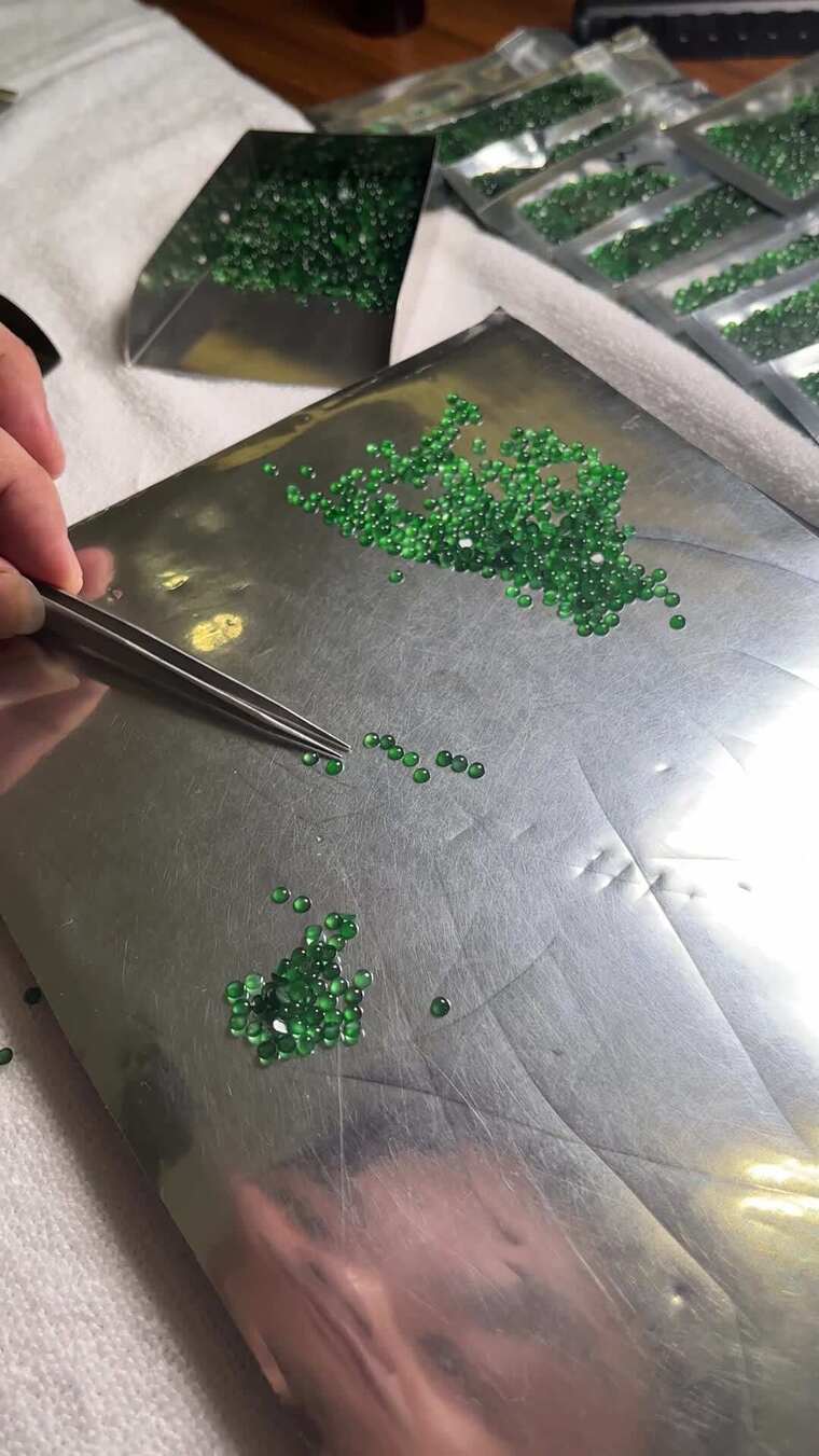 手用镊子挑选翡翠玉石裸石素材