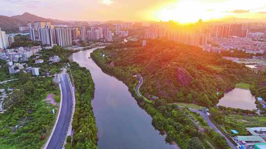 惠州大亚湾夕阳下的城市高楼与山林景观