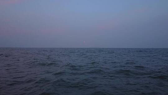 航拍贴紧海平面拍初升的月亮