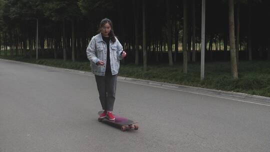 一位女生在校园道路上练习滑板运动