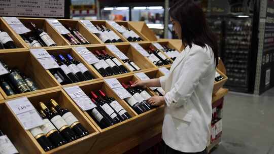 亚洲女性正在超市选购红酒