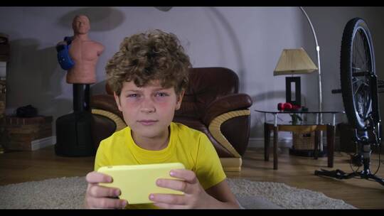 男孩在家里玩电子游戏