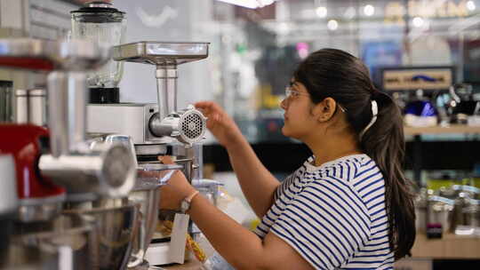 在家电商店，印度女人购买食品加工机