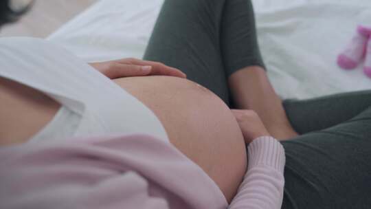 孕妇妈妈抚摸着自己的肚子期待宝宝出生