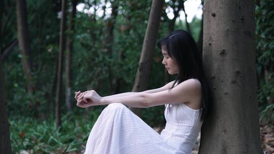 森林里伤感的女孩坐在地上4k视频素材