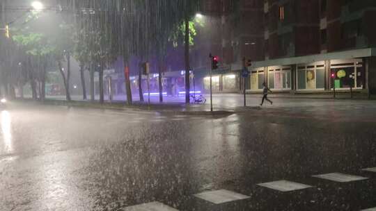 一个人在倾盆大雨中过马路