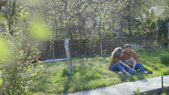坐在草地上的温馨一家人
