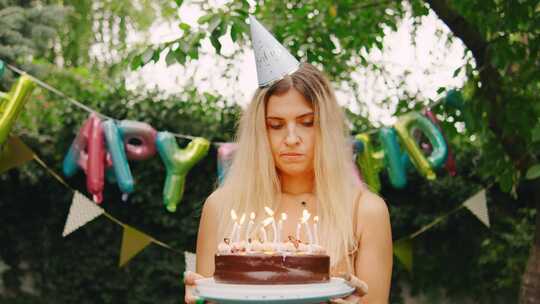 一个戴着派对帽的悲伤女人独自站在节日生日