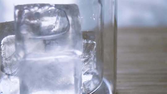玻璃杯中倒入冰块特写