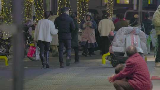 夜晚街道夫妻挽手，行人穿梭的热闹景象