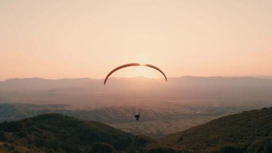 滑翔伞飞行员直接飞向太阳。滑翔翼的和平飞视频素材模板下载