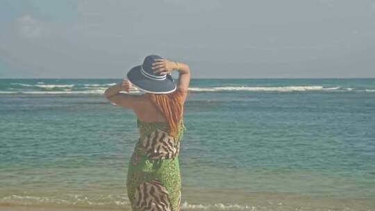 身材妖娆的女孩在独自看海、享受海风和阳光