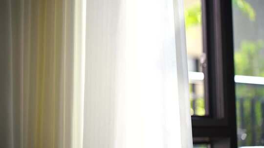 风吹窗帘窗户白色窗帘飘动阳光透过白色窗帘
