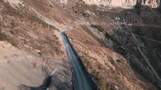 西南陡峭山崖公路行驶汽车