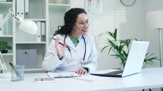快乐的女医生在医院诊所使用笔记本电脑进行