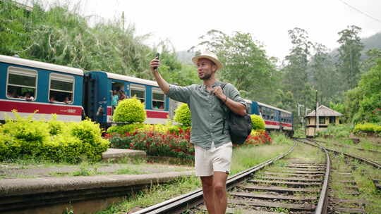 热带火车站的亚洲旅游博客作者与戴帽子微笑