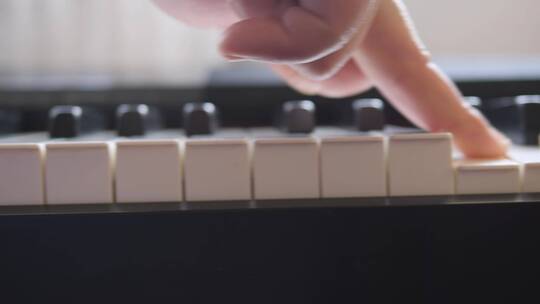 指尖划过钢琴键盘特写