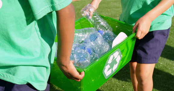 中段学生在学校操场上搬运塑料瓶垃圾