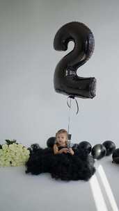 蹒跚学步的二岁生日庆祝活动穿着黑色连衣裙