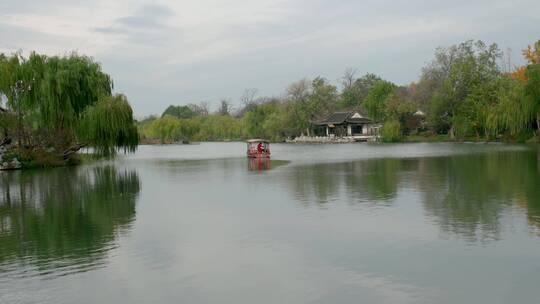 扬州瘦西湖阴雨天在雨中行驶的摇橹船及船娘