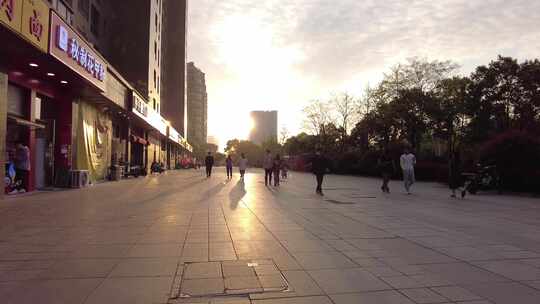 城市夕阳下的路人散步