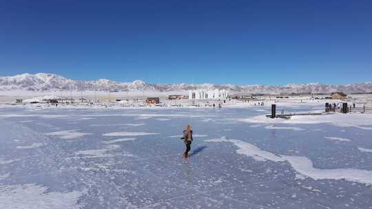 航拍女孩在冬季新疆赛里木湖冰冻湖面上玩耍