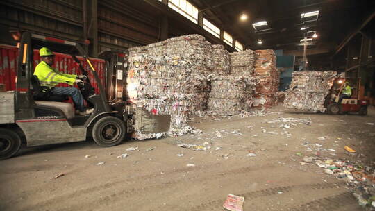工人开着叉车在回收中心移动垃圾视频素材模板下载